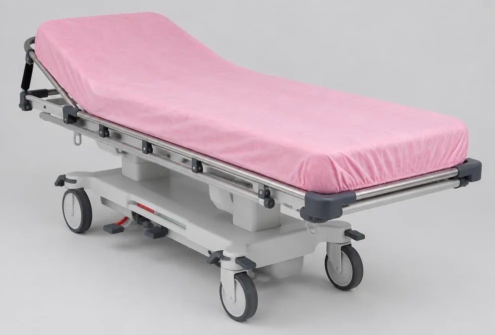 Sábana resortada desechable rosada ajustada en una camilla hospitalaria